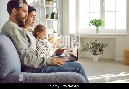 Giovane famiglia che ha consultazione telemedicina online con il loro medico pediatrico. Foto Stock