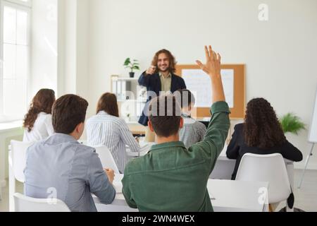 Studente adolescente che alza la mano durante la lezione Foto Stock