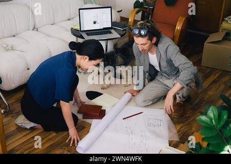 Vista ad alto angolo di architetti multirazziali di sesso maschile e femminile che discutono del progetto in casa Foto Stock