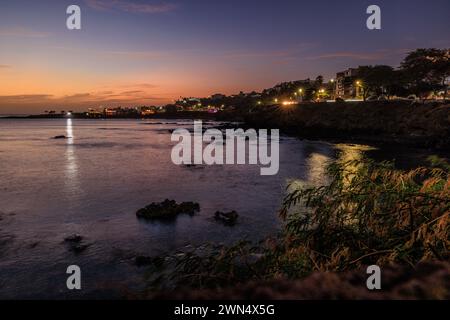 Scena notturna delle luci della città di Praia, capitale di Cabo Verde, riprodotta nelle calme acque di una baia a lunga esposizione Foto Stock