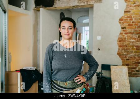 Ritratto di una donna sicura di sé in piedi con la mano sul fianco nel cantiere Foto Stock