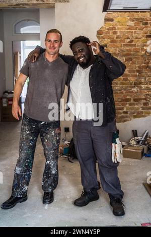 Ritratto di diversi carpentieri maschi sorridenti in piedi insieme in appartamento Foto Stock