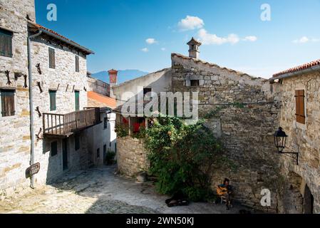 Un musicista di strada suona la chitarra all'ingresso della città vecchia. Vista dall'alto. Hum, Istria, Croazia 2018 Foto Stock