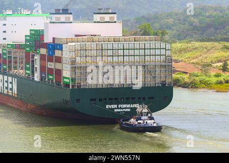 Canale di Panama, Panama - 23 gennaio 2024: Rimorchiatore che assiste la nave portacontainer sempre in avanti per navigare nel Canale di Panama. Foto Stock