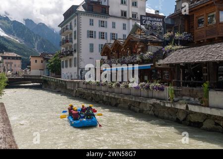 Rafting sul fiume Arve attraverso il centro della città alpina con il Monte bianco sullo sfondo in estate, Chamonix, alta Savoia, Francia Foto Stock