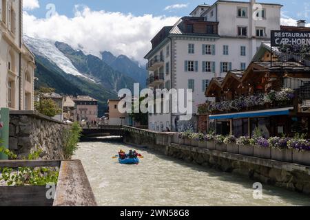 Rafting sul fiume Arve attraverso il centro della città alpina con il Monte bianco sullo sfondo in estate, Chamonix, alta Savoia, Francia Foto Stock