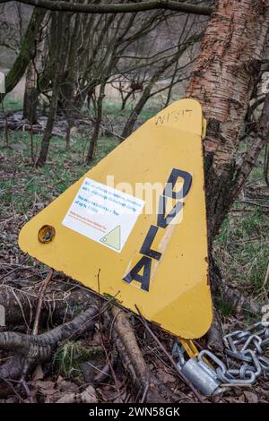 morsetto della ruota giallo rimosso illegalmente dal veicolo e scaricato sul lato del paese Foto Stock