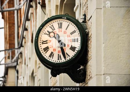 Orologio classico con numeri romani da una stazione ferroviaria di Aranjuez Foto Stock