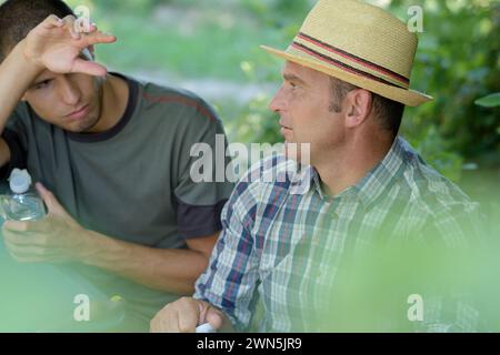 contadino stanco nel vigneto che parla con il direttore Foto Stock