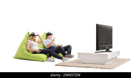 Giovane coppia entusiasta che guarda la tv con cuffie per realtà virtuale isolate su sfondo bianco Foto Stock