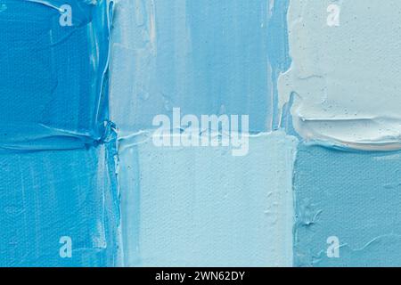 Primo piano di quadrati dipinti con vernice acrilica in tonalità blu chiaro e turchese. Sfondo tela testurizzata full frame ad alta risoluzione, spazio di copia Foto Stock