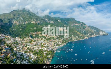 L'iconica cittadina di Positano sulla scogliera si estende fino alle acque azzurre della Costiera Amalfitana, emblema del pittoresco splendore del mare italiano. Foto Stock