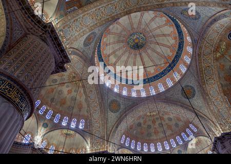 interno della moschea blu di istanbul, con le sue vetrate colorate, i suoi grandi archi, l'impressionante soffitto con la sua volta centrale Foto Stock