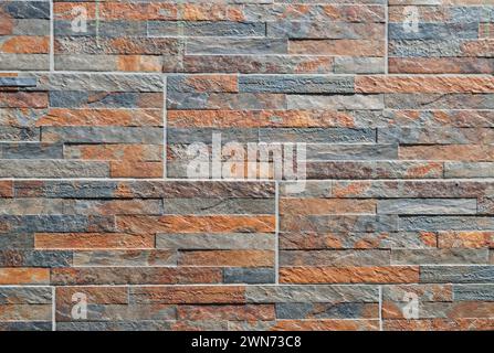 Rivestimento decorativo con pietra o piastrelle con imitazione di un motivo in pietra. Decorazioni interne ed esterne degli edifici. Architettura urbana. Schema pietra Foto Stock