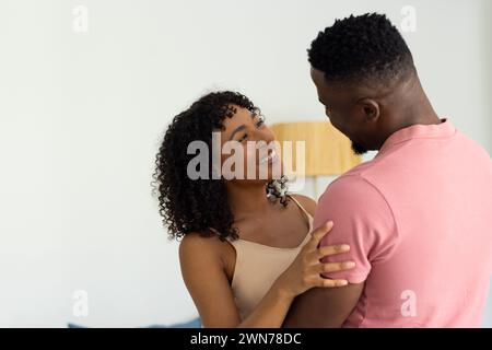 La coppia afroamericana birazziale condivide un momento gioioso a casa Foto Stock