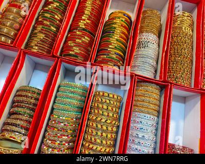 Braccialetti colorati indiani esposti in un negozio locale in un mercato di Pune, India, questi bellissimi braccialetti sono realizzati in vetro utilizzato come accessori di bellezza da in Foto Stock