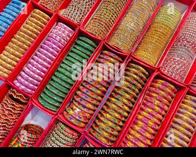 Braccialetti colorati indiani esposti in un negozio locale in un mercato di Pune, India, questi bellissimi braccialetti sono realizzati in vetro utilizzato come accessori di bellezza da in Foto Stock