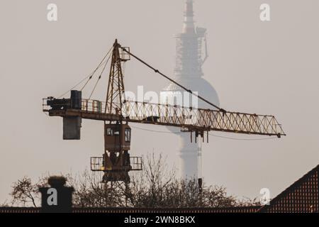 Ein Kran zeichnet sich ab vor dem Berliner Fernsehturm a Berlino, 29.02.2024. Berlin Deutschland *** Una gru si infila davanti alla televisione di Berlino Foto Stock