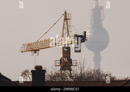 Ein Kran zeichnet sich ab vor dem Berliner Fernsehturm a Berlino, 29.02.2024. Berlin Deutschland *** Una gru si infila davanti alla televisione di Berlino Foto Stock