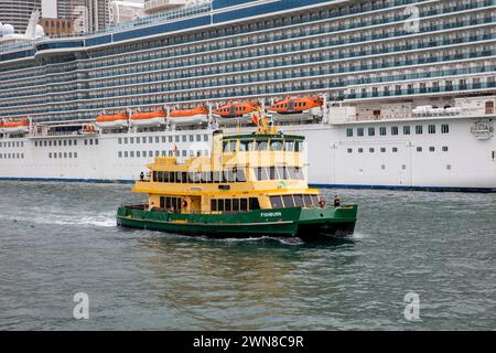 La nave da crociera Majestic Princess ormeggiata sulla banchina circolare di Sydney con il traghetto MV Fishburn che naviga oltre, New South Wales, Australia, 2024 Foto Stock