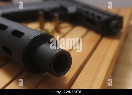 Un primo piano di pistola su un tavolo di legno Foto Stock