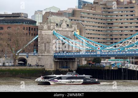 Una barca sul fiume Uber passa di fronte al Tower Bridge e alla Torre di Londra in una mattina di febbraio. Foto Stock