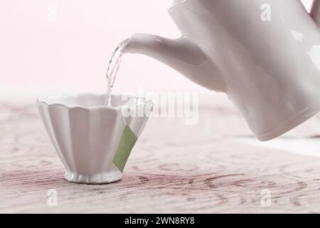 Elegante teiera versata nella tazza da tè Foto Stock