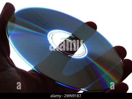 Tenere in mano un CD con sfondo chiaro Foto Stock