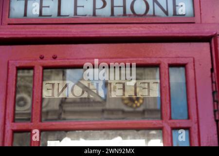 Westminster si riflette nella finestra della cabina telefonica. Foto Stock