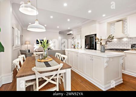 Cucina in stile francese e sala da pranzo con tavolo da pranzo in legno in primo piano Foto Stock