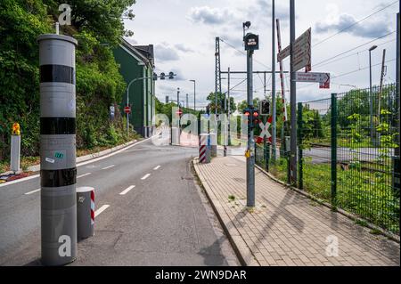 Una strada vuota con semafori e binari ferroviari, circondata da vegetazione verde e cielo nuvoloso, Ruhr Bridge, Dahlhausen, Bochum, Ruhr Foto Stock