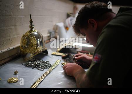 Un soldato dei Blues and Royals, un reggimento di cavalleria dell'esercito britannico e parte della Household Cavalry, prepara la sua uniforme cerimoniale, prima di giudicare durante la Princess Elizabeth Cup, la coppa annuale per i migliori soldati, a Hyde Park Barracks a Londra. I vincitori incontreranno re Carlo III al Royal Windsor Horse Show di maggio, quando il vincitore assoluto riceverà la coppa. Data foto: Venerdì 1 marzo 2024. Foto Stock