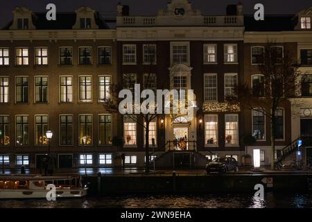 Le case si illuminano di notte sul canale Herengracht, Amsterdam, Paesi Bassi Foto Stock