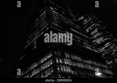 Potente paesaggio architettonico monocromatico astratto di uffici Sky-scraper illuminati di notte su Bishopsgate vicino a Liverpool St, City of London Foto Stock