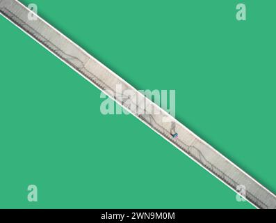 Vista aerea minimalista di un uomo che cammina sopra un ponte. Foto Stock