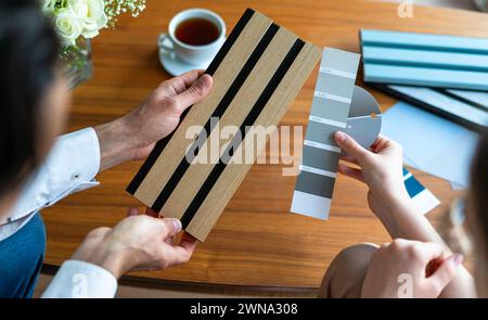 Designer di interni e cliente che scelgono materiali di design per la casa da campioni di pannelli acustici nel negozio di design. Nuovo stile nordico Foto Stock