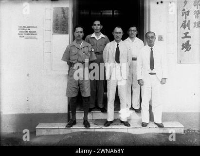 Due ufficiali giapponesi e tre civili giapponesi di fronte a un edificio di uffici in Indonesia (Tidak Ada Lowongan Pekerdjaan) 1942-1945 Foto Stock