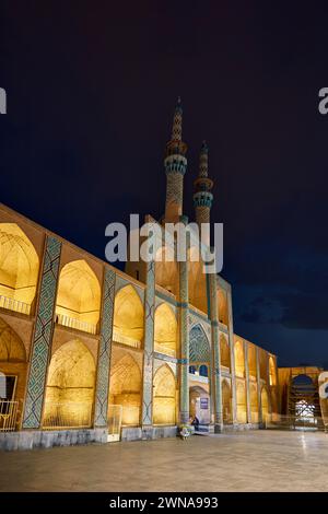 Takyeh (edificio dove i musulmani sciiti si riuniscono per piangere la morte di Husayn) e minareti del complesso Amir Chakhmaq illuminati di notte. Yazd, Iran. Foto Stock