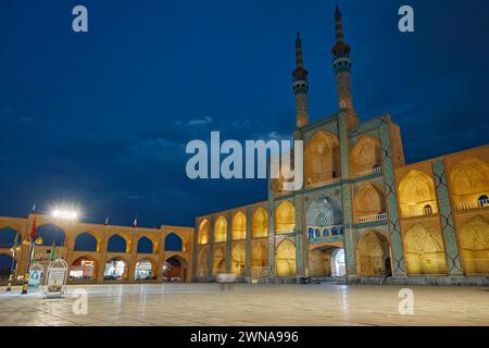 Takyeh (edificio dove i musulmani sciiti si riuniscono per piangere la morte di Husayn) e minareti del complesso Amir Chakhmaq illuminati di notte. Yazd, Iran. Foto Stock