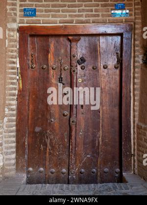 Vecchia porta d'ingresso in legno di una casa nella città vecchia di Yazd, Iran. Foto Stock