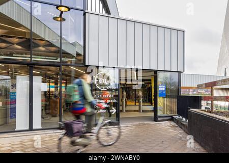 EDE, Paesi Bassi - 1 marzo 2024: Motociclista che entra nel moderno parcheggio sicuro per biciclette presso la stazione centrale di Ede-Wageningen nei Paesi Bassi Foto Stock