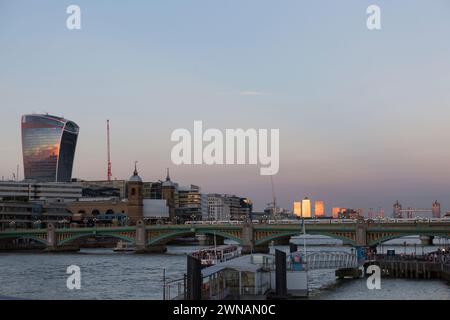 Regno Unito, Londra, banchina delle Canarie con luce del sole dorata e la città di londra con l'edificio Walkie Talkie e Southwark Bridge in primo piano. Foto Stock