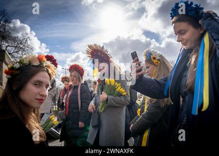 Ucraini e sostenitori eseguono una marcia di protesta di massa attraverso il centro di Londra per radunarsi in Trafalgar Square nel secondo anniversario dell'invasione russa Foto Stock