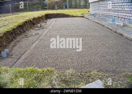 Livellamento della superficie del terreno da una piccola pietra, per la posa di lastre di pavimentazione Foto Stock
