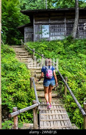 Giovane donna caucasica che visita il Villaggio Folcloristico Hida, il museo all'aperto Hida no Sato a Takayama, Giappone Foto Stock