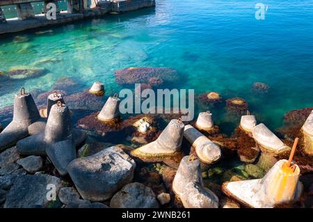 Protezione dell'impatto delle onde di tempesta. Capsule TETRA per rafforzare il litorale. Breakwater sulla costa del mare. Frangiflutti in calcestruzzo. Foto Stock