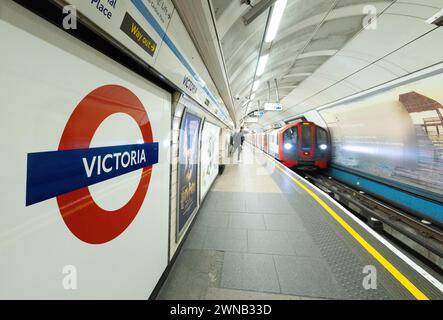 Stazione della metropolitana Victoria Londra - cartello della stazione della metropolitana Victoria, binario e treno in avvicinamento, trasporto pubblico per Londra, Londra Regno Unito Foto Stock