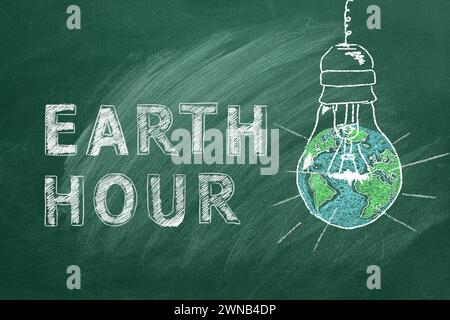 Lampadine con scritta EARTH HOUR disegnate a mano in gesso su un greenboard scolastico. Salvare il mondo. Salvate il nostro pianeta. Foto Stock