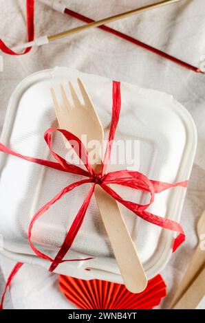 Scatola bianca per torte bento con fiocco rosso. Confezione regalo con gustoso bento. Confezione per torte. Consegna. Foto Stock