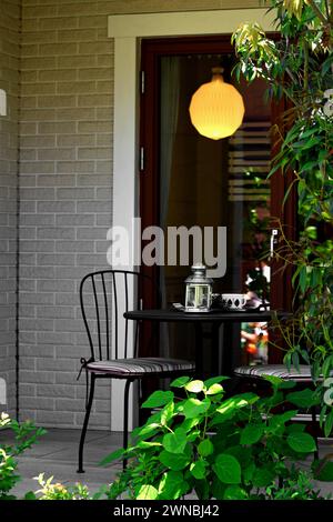 Una piccola terrazza di una casa e un tavolo da caffe' vuoto Foto Stock